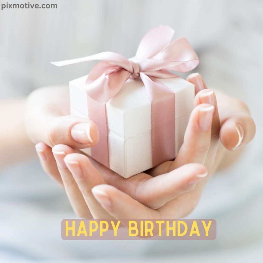 A closeup of hand holding a gift box with ribbon and a bold yellow birthday typography